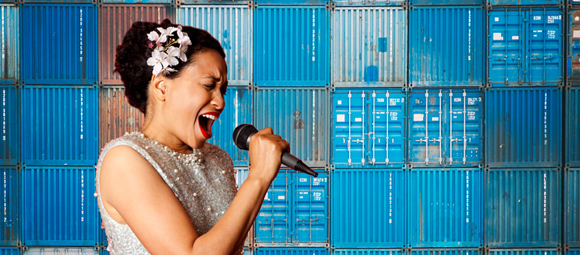 Singer Performing in Front of Shipping Containers